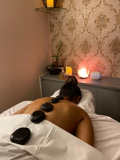 Massoterapeuta Liane fazendo massagem com pedras quentes
